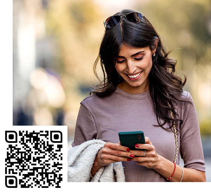 Woman walking on street and looking at phone
